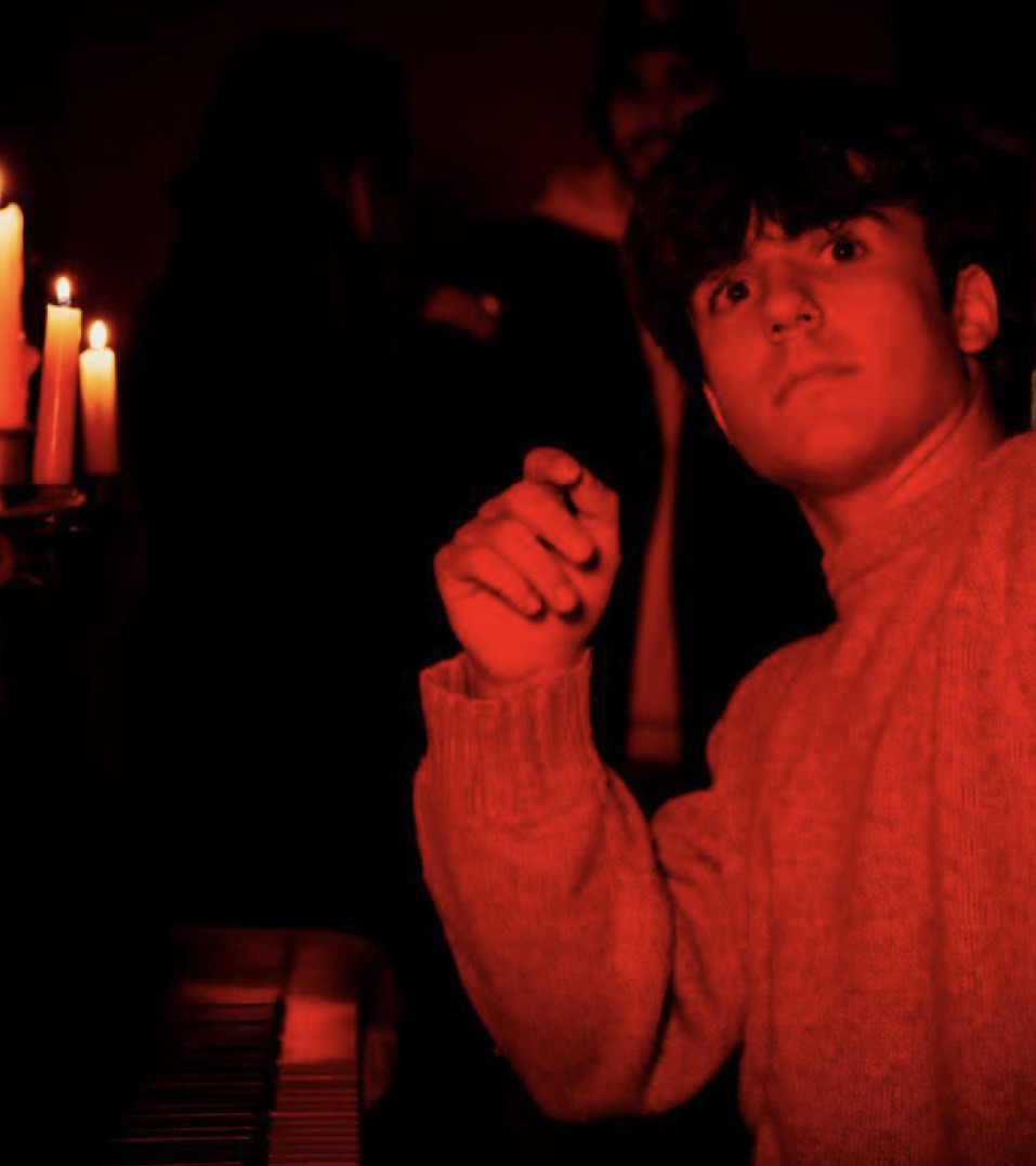 Ragazzo in maglione rosso a lume di candela